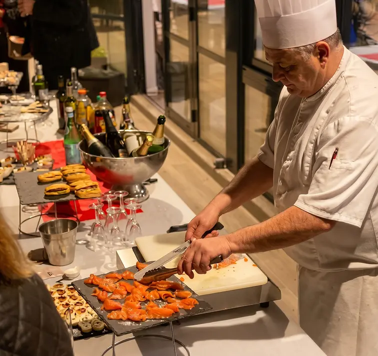 Chef découpant un saumon pendant un cocktail de séminaire d'entreprise à Meyreuil